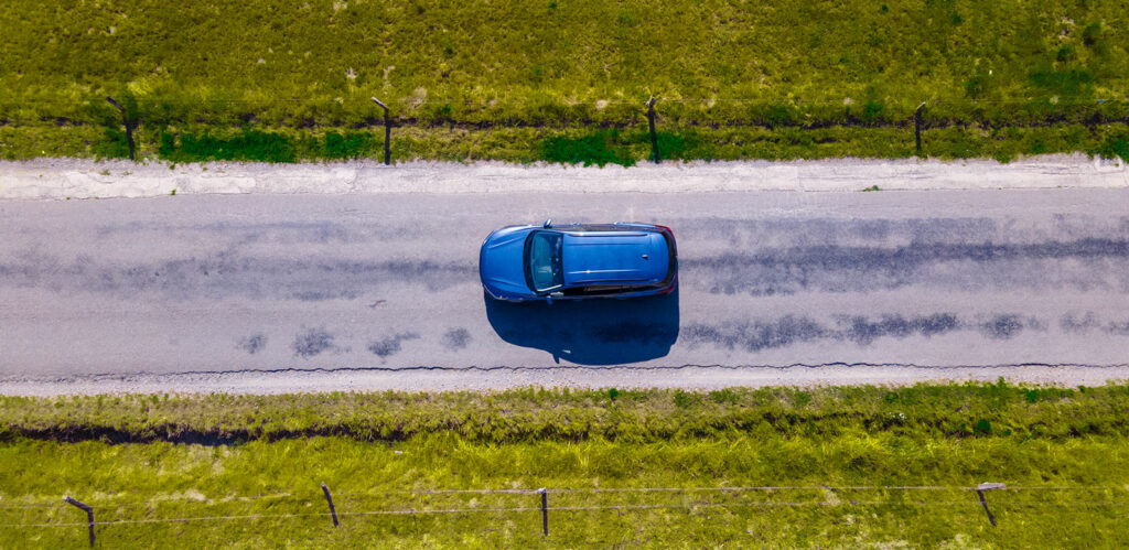 Voiture bleue sur une route de campagne vue du dessus