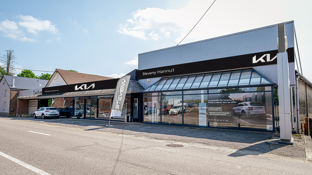 Concession Kia Hannut Façade de la concession Steveny Hannut avec enseigne Kia et voitures stationnées devant le bâtiment moderne.
