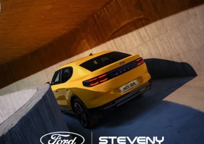 Voiture Ford Capri jaune garée dans un tunnel en béton, vue arrière, logo Ford et Steveny en bas.
