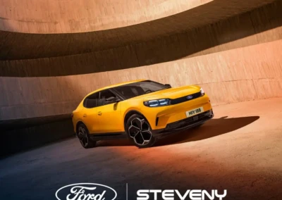 Voiture Ford jaune dans un espace circulaire en béton, avec logos Ford et Steveny en bas de l'image.