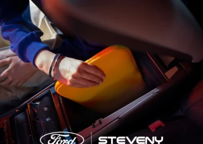 Une personne place un étui jaune dans le compartiment central d'une voiture Ford.