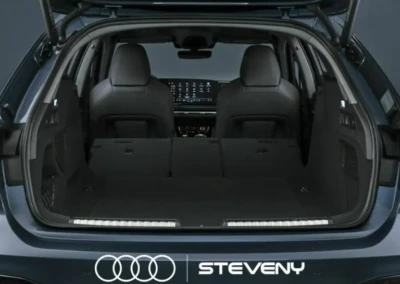 Coffre ouvert d'une Audi A5 Avant, montrant un espace de chargement spacieux avec sièges rabattus, logo Steveny visible.