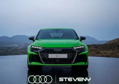 Voiture Audi RS3 verte vue de face sur fond de paysage montagneux, avec logo Steveny en bas.