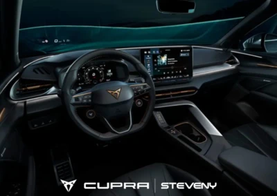 Intérieur de la CUPRA Terramar avec volant et tableau de bord numériques, écran central affichant une interface multimédia.