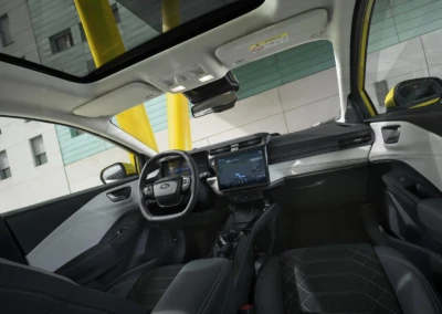 Intérieur d'une Ford Puma 2024 avec tableau de bord numérique, volant noir et sièges en cuir, toit panoramique visible.