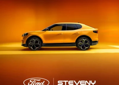 Voiture Ford orange sur fond orange avec logo Steveny en bas.