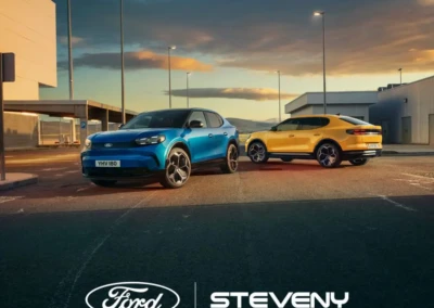Deux voitures Ford, une bleue et une jaune, stationnées sur un parking au crépuscule, avec logos Ford et Steveny.