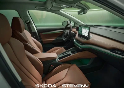 Intérieur de la Skoda Enyaq 2025 avec sièges en cuir brun et tableau de bord moderne, affichant un écran numérique.