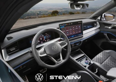 Intérieur du Volkswagen Tayron avec tableau de bord numérique, volant multifonction et écran central tactile, vu de l'avant.