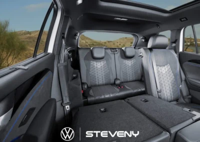 Intérieur de la Volkswagen Tayron avec sièges arrière rabattus, offrant un espace de chargement spacieux sous un ciel bleu.