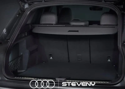 Coffre ouvert d'une Audi Q5 noir, montrant un espace de rangement spacieux et vide, avec le logo Steveny visible.