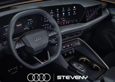 Volant et tableau de bord numériques de l'Audi Q5, avec éclairage intérieur et logo Audi et Steveny visibles.
