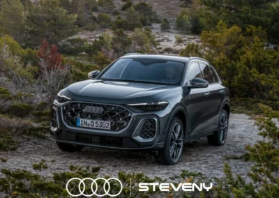 SUV Audi Q5 gris stationné sur un chemin entouré de végétation, avec le logo Steveny en bas de l'image.