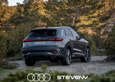 SUV Audi Q5 gris stationné sur un chemin de terre, entouré de végétation, avec logo Steveny en bas.