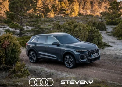 SUV Audi Q5 gris sur chemin de terre, entouré de végétation et d'arbres, avec logo Steveny en bas.